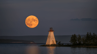 A supermoon rises over a lighthouse on Kidston Island off the coast of Nova Scotia, Canada