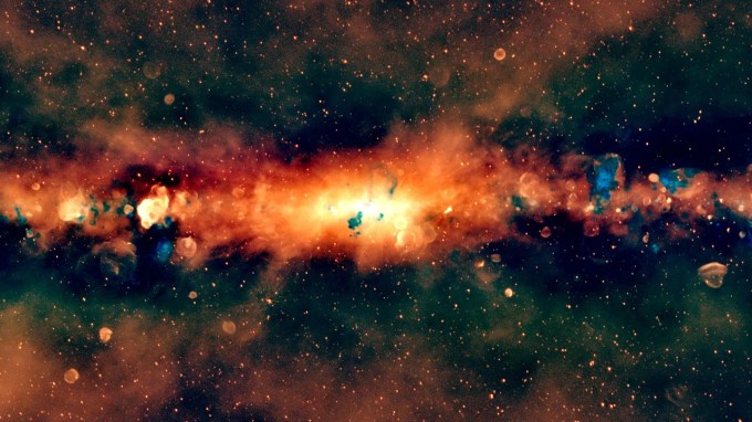 a radio-light, edge-on view of the Milky Way, artificially colored to show lower-frequency waves in red and higher-frequency waves in blue, shows a line of bright red and orange light with scattered blue bubbles