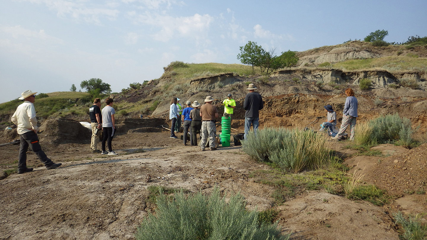 a photo of a group of people in a dry desert area for a dinosaur fossil dig