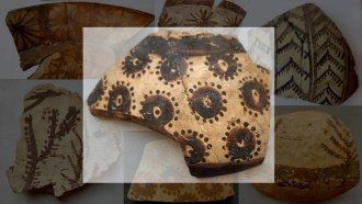 a fragment of pottery is decorated with dark circles surrounded by smaller dark dots