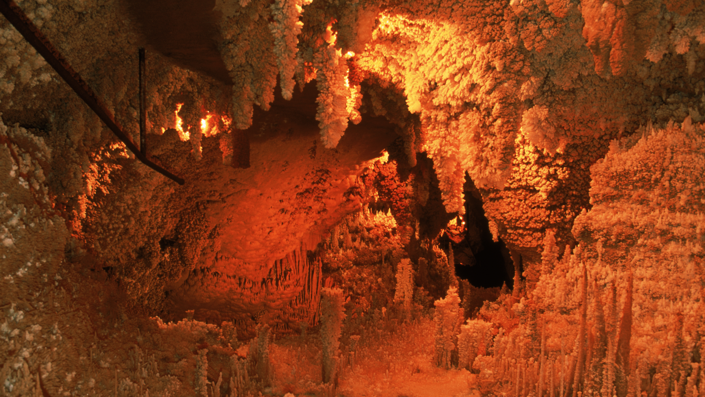 the inside of a cave with surfaces covered in clusters of knobby minerals