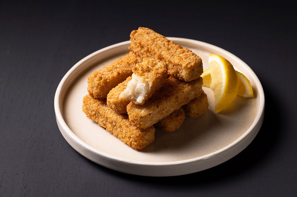 a plate of fish fingers with lemon on the side
