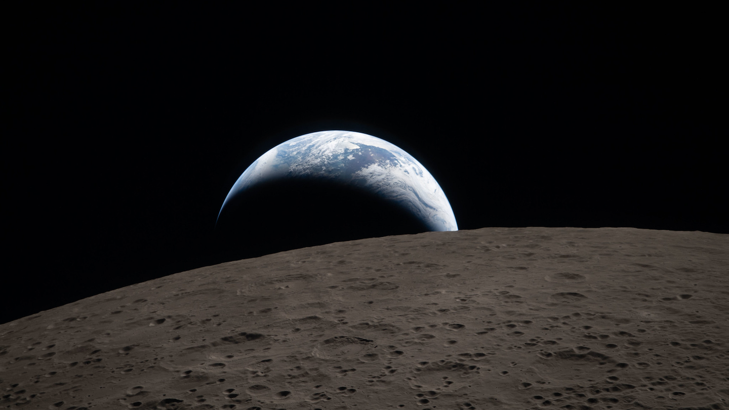 an Artemis II mission photo of the Earth seen rising over the surface of the moon