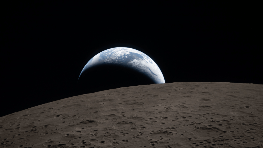 an Artemis II mission photo of the Earth seen rising over the surface of the moon