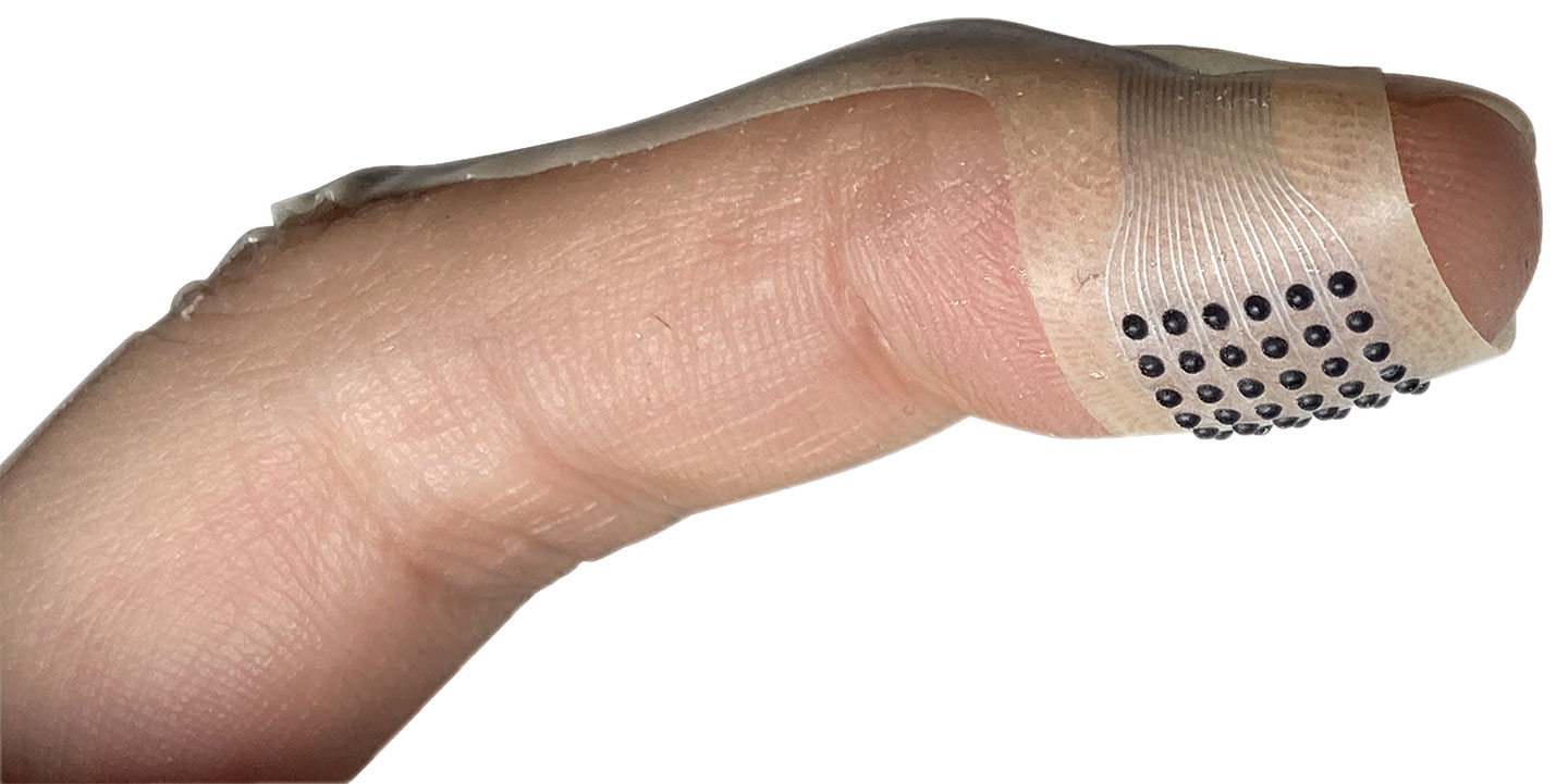 a band-aid wraps around the tip of an index finger, studded with tiny black dots