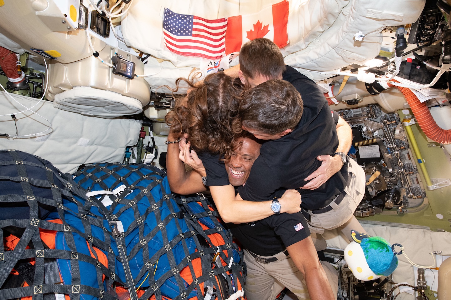 the four Artemis astronauts share a group hug inside the capsule