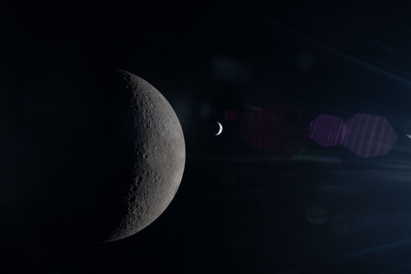 the crescent of the moon in the foreground, and a tiny crescent of illuminated earth in the background