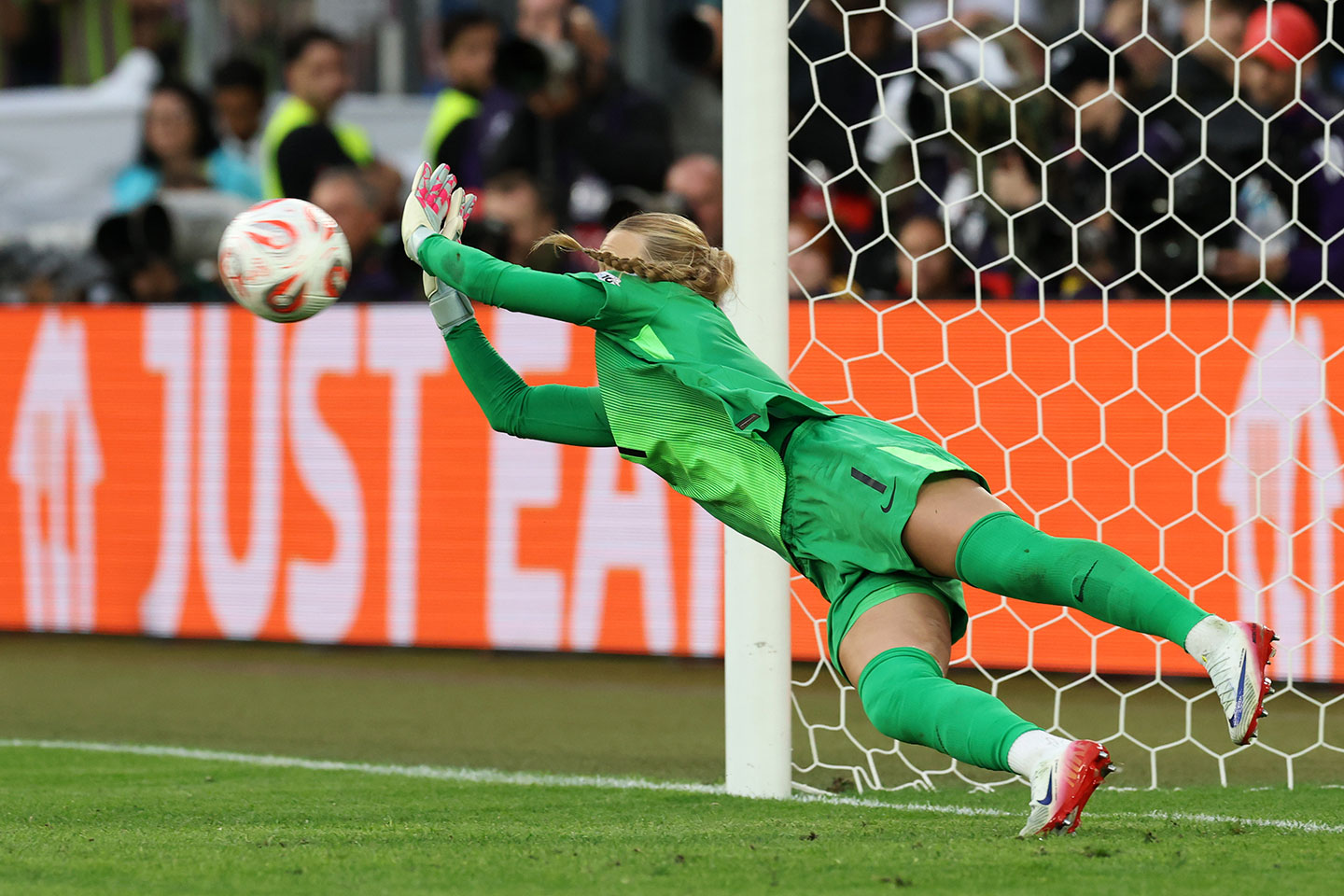 Goalkeeper Hannah Hampton dives across the goal to block a penalty kick