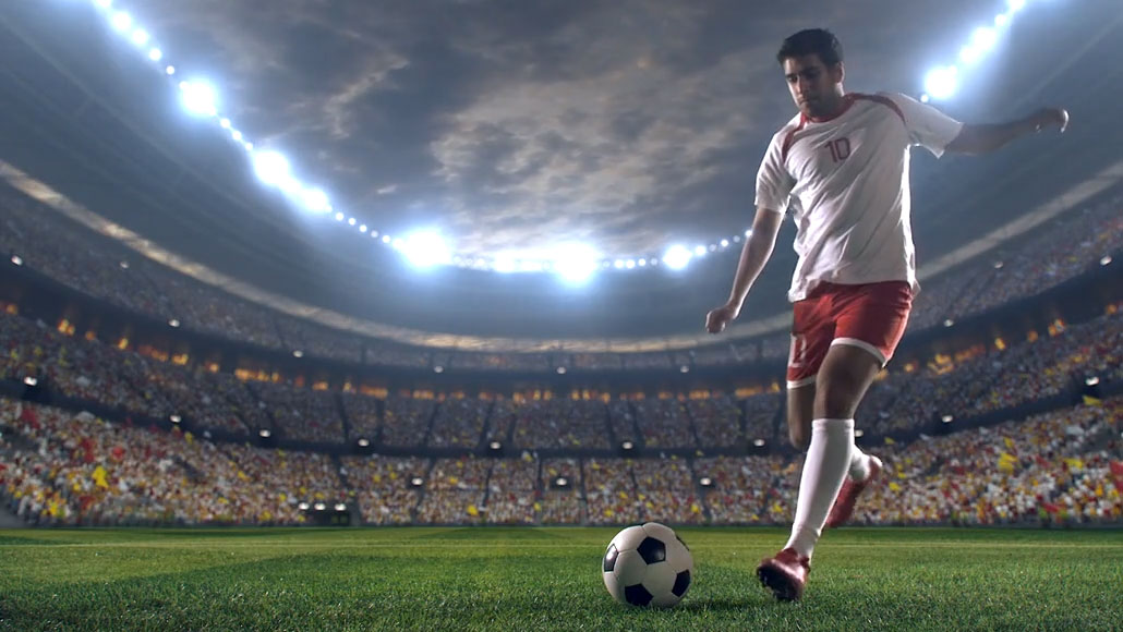 a male soccer player kicking a ball towards the goal during a game