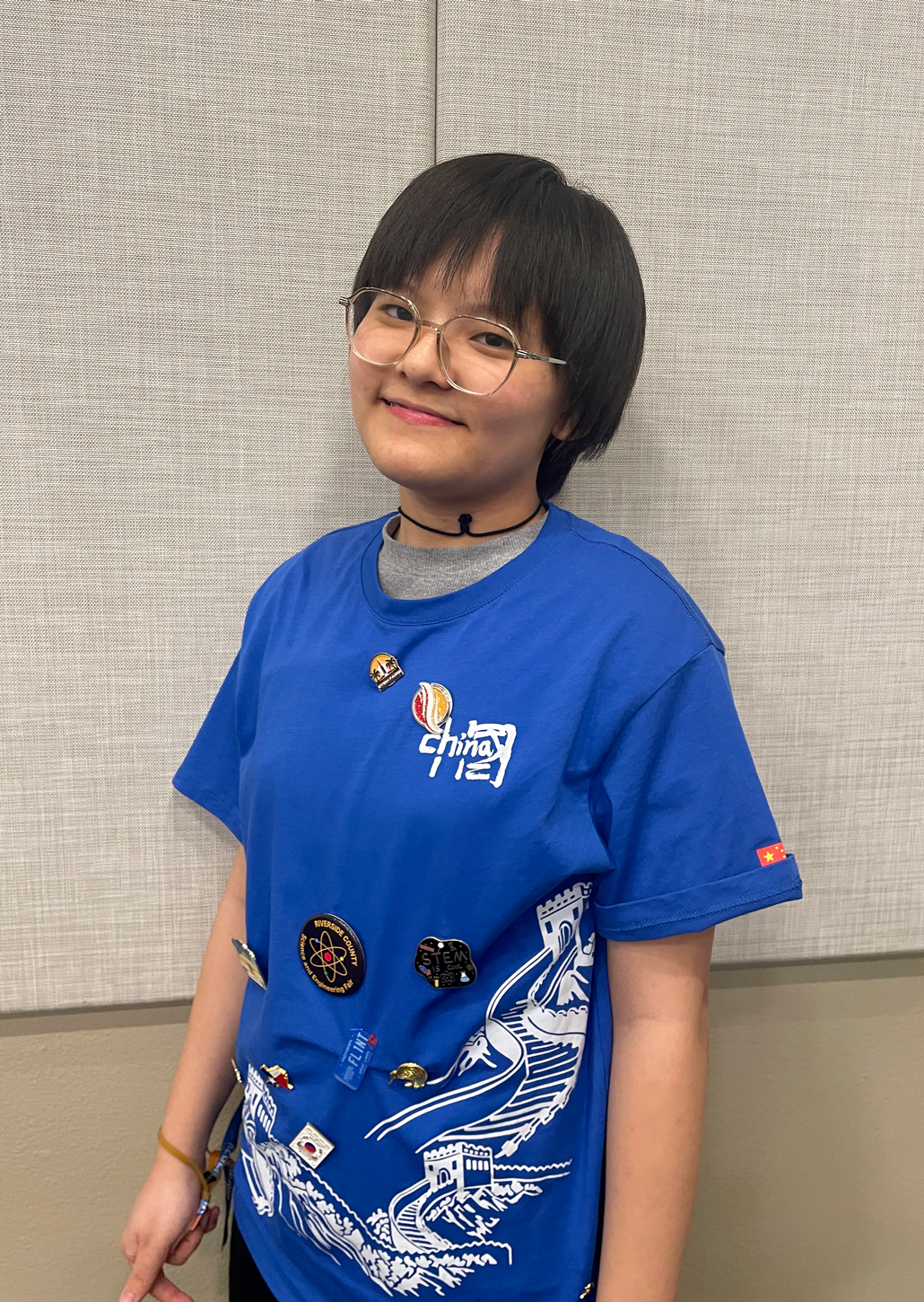 A photo of Sopha Zeng, a smiling young woman with a short haircut and cute glasses