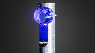 A translucent blue cylindrical crystal mounted on a post used to create the first nuclear clock