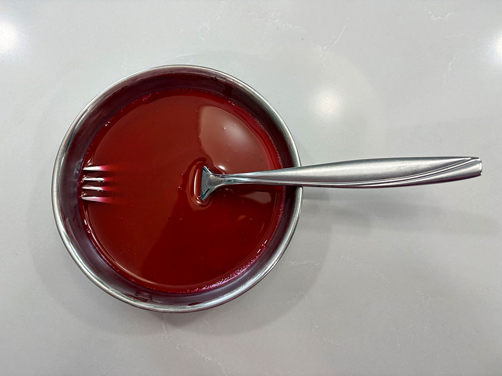 a bowl of dark red liquid with a fork in it