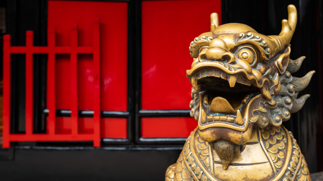 a bronze statue of a dragon outside a Chinese temple