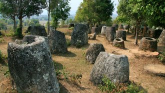 An image of site 2 of the Plain of Jars, Phonsavan, Xiang Khouang Provance, Laos. There are numerous large ancient stone jars scattered across clearing.The Plain of Jars in Laos is a collection of thousands of large, ancient stone vessels. Local legend says they stored rice wine for giants. Some thought they may might once have stored food and water. Now researchers say they’re part of a vast burial complex.
