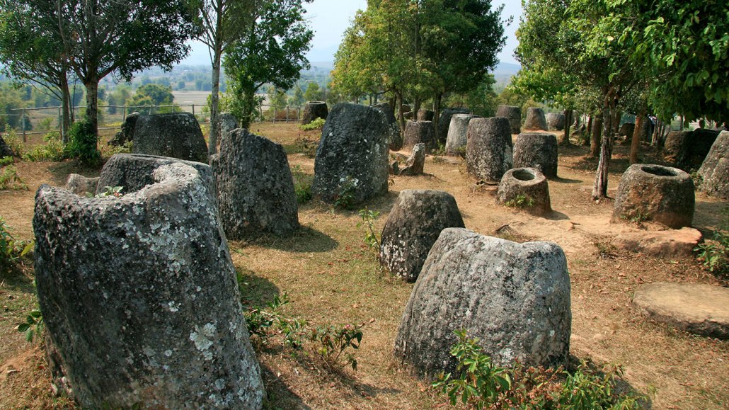 An image of site 2 of the Plain of Jars, Phonsavan, Xiang Khouang Provance, Laos. There are numerous large ancient stone jars scattered across clearing.The Plain of Jars in Laos is a collection of thousands of large, ancient stone vessels. Local legend says they stored rice wine for giants. Some thought they may might once have stored food and water. Now researchers say they’re part of a vast burial complex.