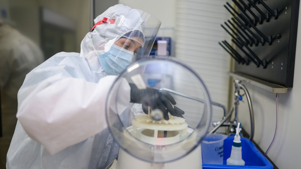 A researcher puts ancient poop into a centrifuge