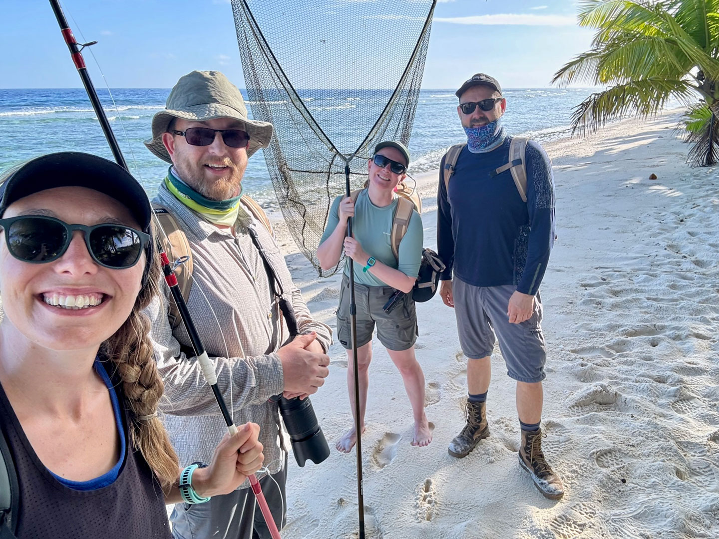 a photo of the four scientists taking a selfie on the beach together