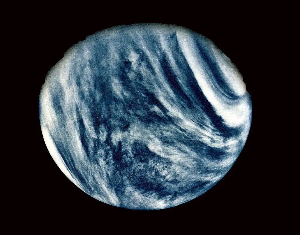 an image of the planet Venus against a black background, showing swirling light-colored clouds