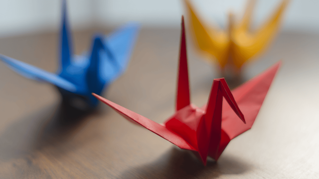 a red, blue and yellow paper origami crane