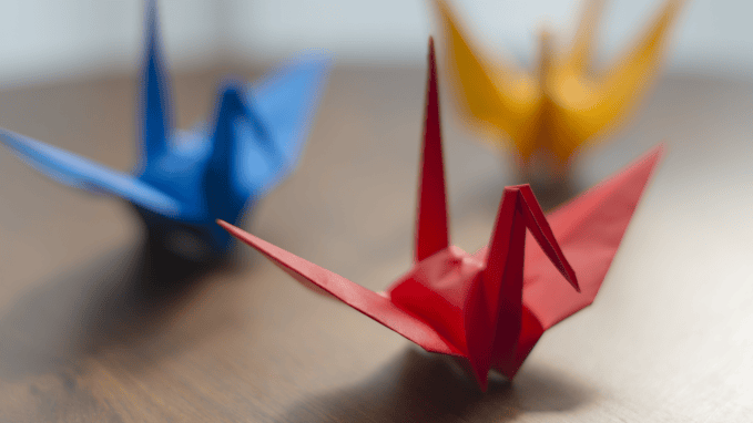 a red, blue and yellow paper origami crane